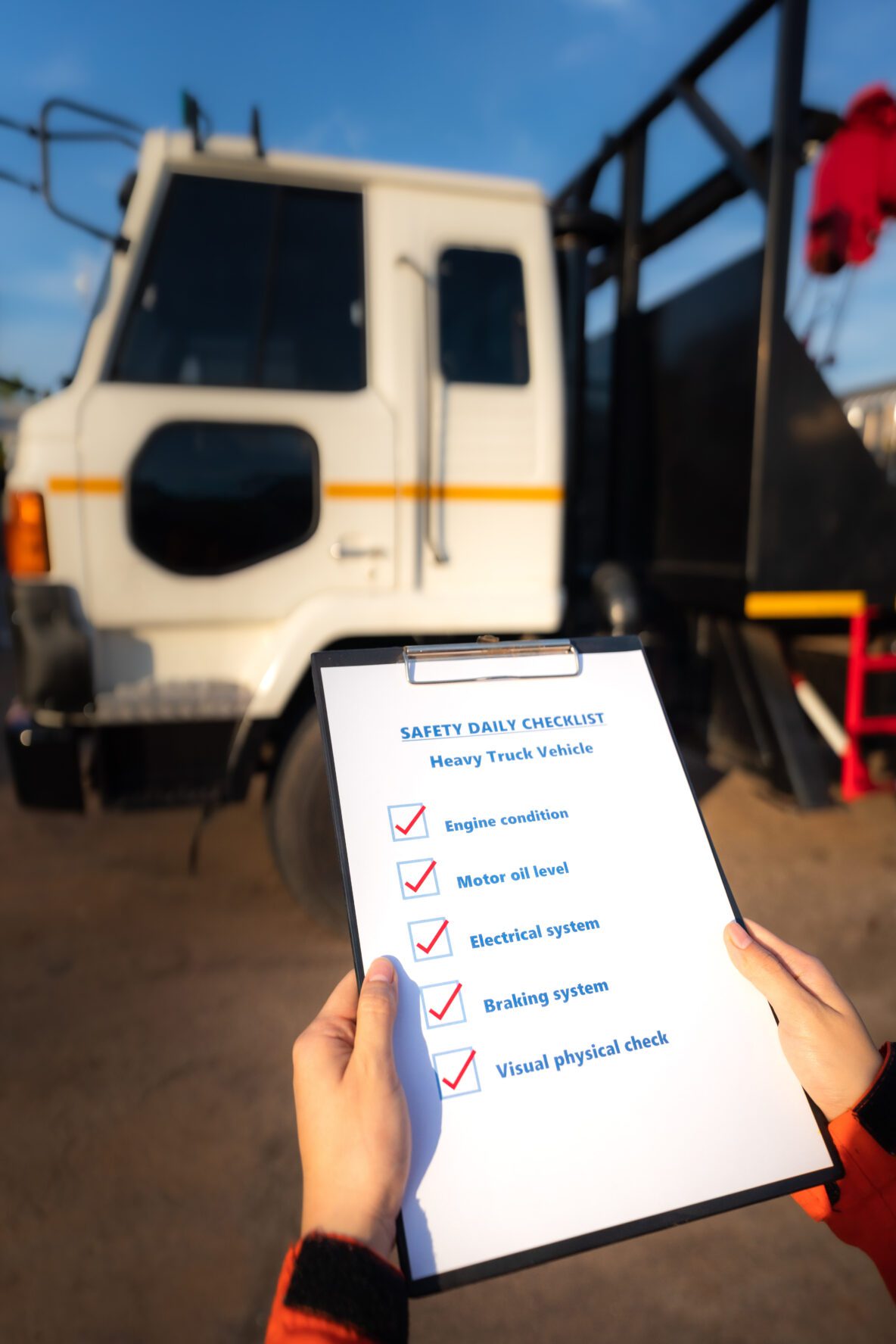 mechanic worker is using the daily checklist form to verify and inspection a heavy truck